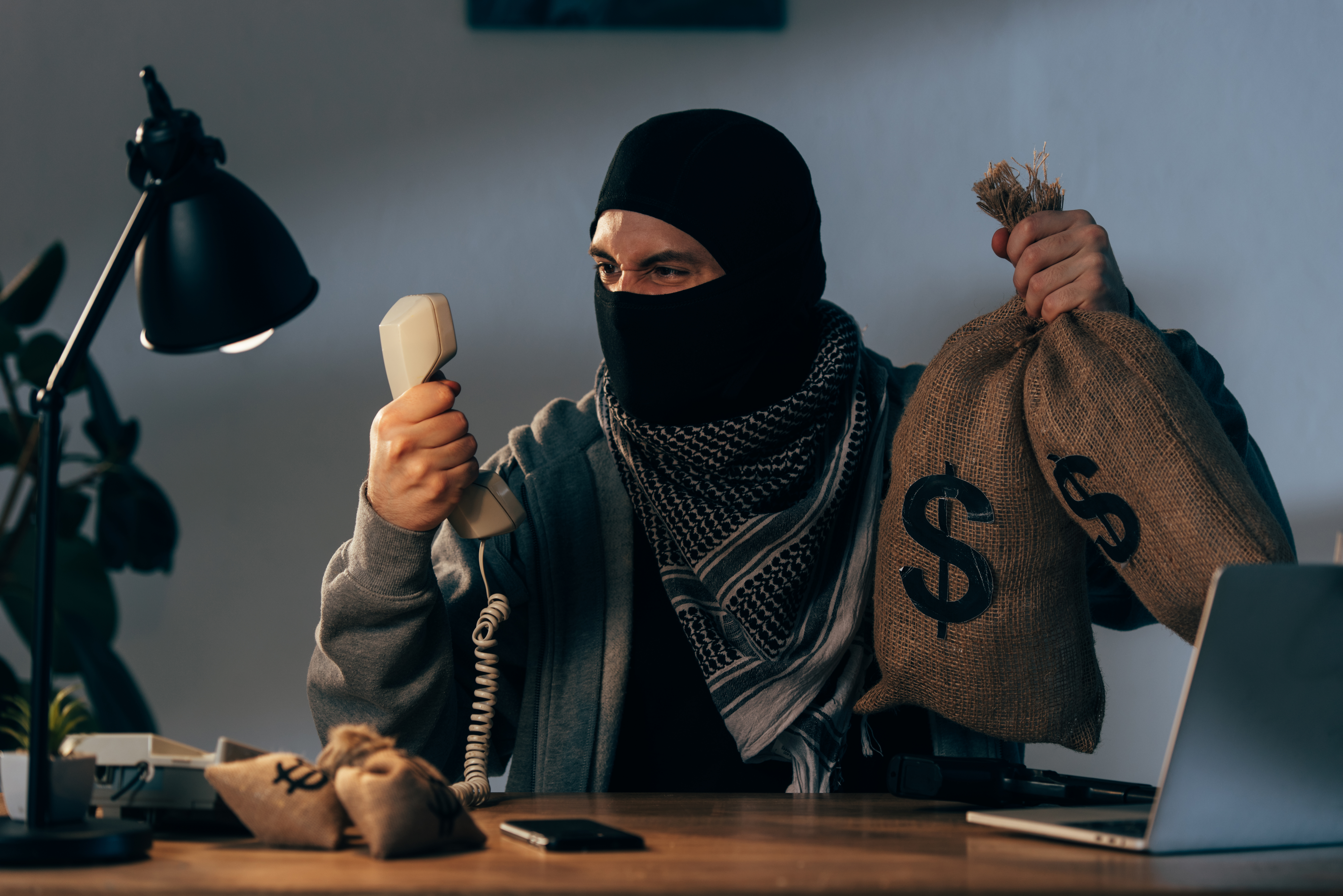 man in ski mask holding phone and money 2026 03 11 07 04 55 utc