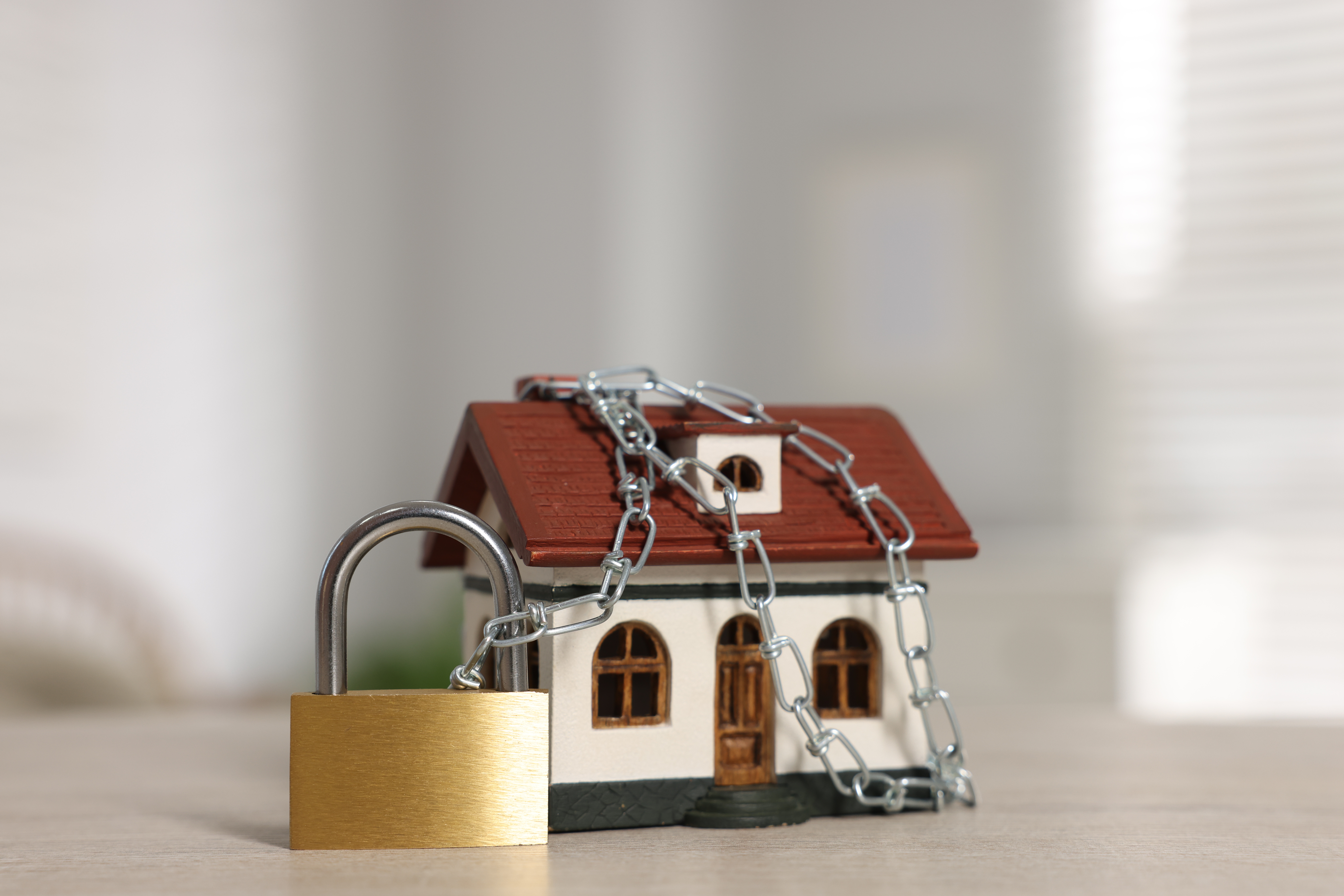 model house wrapped in chain with brass padlock on 2026 05 07 06 16 13 utc